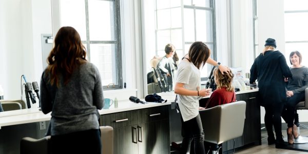 woman in gray sweater and black pants standing in front of mirror